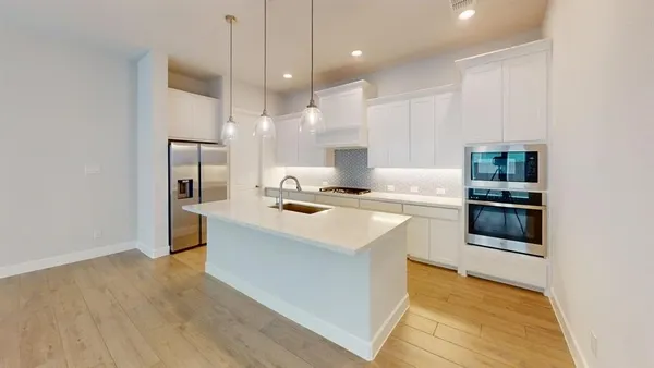 a kitchen with kitchen island a sink stainless steel appliances and cabinets