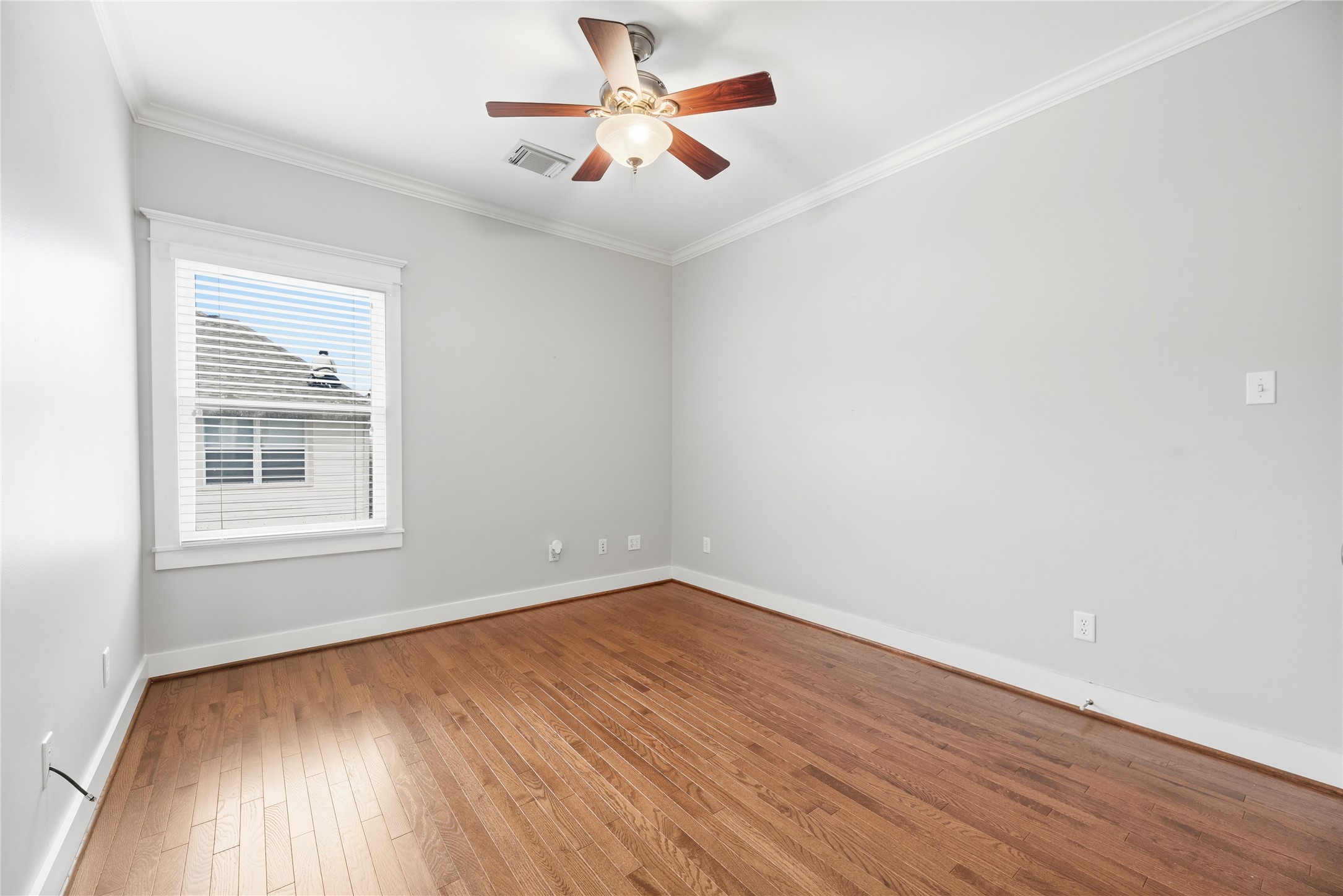 1505 Prince Street Houston, TX 77008 - Photo 25 of 39 Spacious secondary bedroom features handsome molding, natural light, a timeless ceiling fan, and hardwood floors.