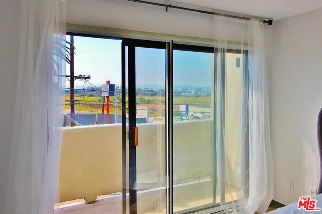 a view of an empty room with wooden floor and closet