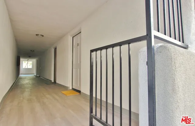 a view of a hallway with wooden floor and staircase
