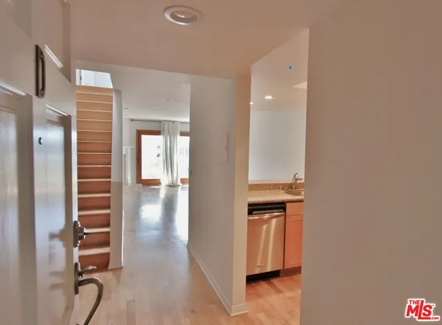 a view of a hallway with wooden floor and staircase