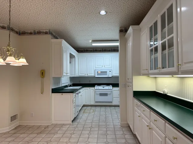 a kitchen with granite countertop a sink a stove and cabinets