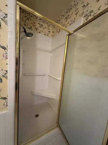 a bathroom with a granite countertop sink a toilet a mirror and shower