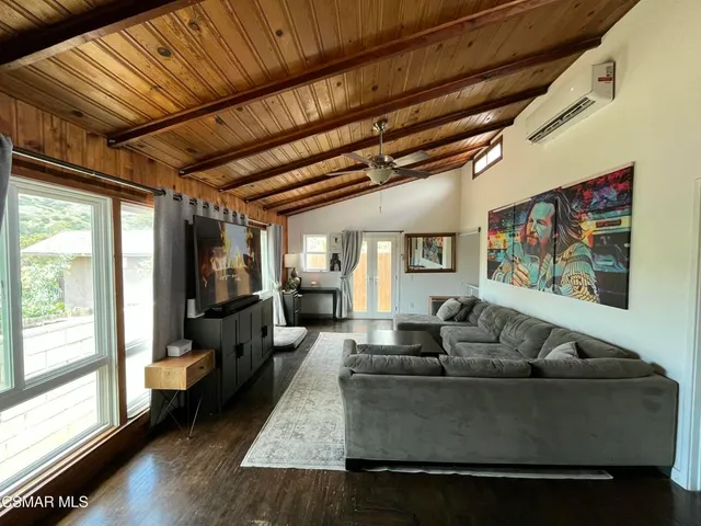 a living room with furniture wooden floor and a large window