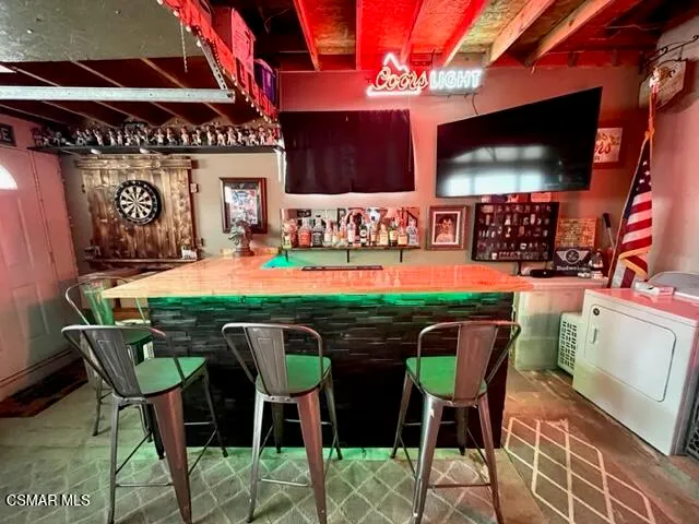 a patio with a table and chairs and potted plants