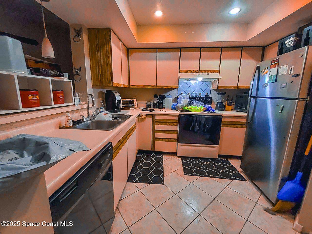 1515 Huntington Lane, Unit 628 Rockledge, FL 32955 - Photo 13 of 18 a kitchen with stainless steel appliances granite countertop a refrigerator a stove and a sink