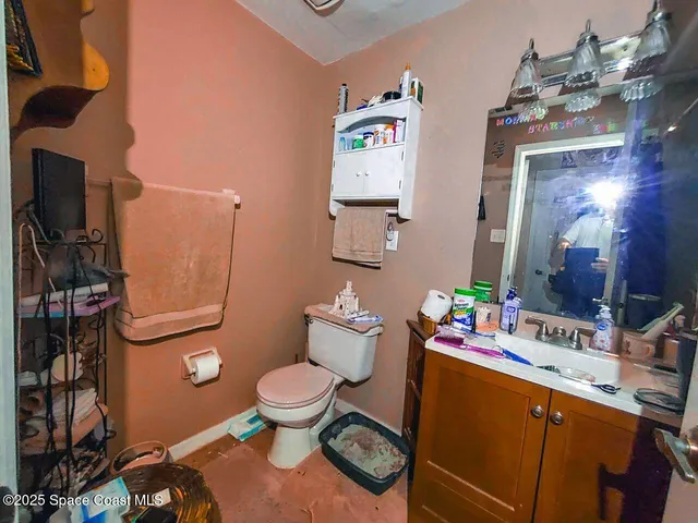 a bathroom with a toilet sink vanity and mirror