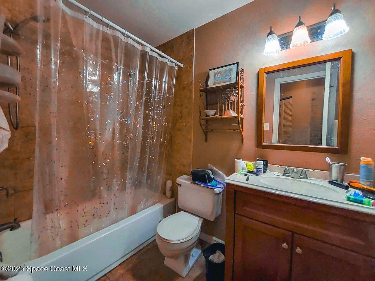1515 Huntington Lane, Unit 628 Rockledge, FL 32955 - Photo 10 of 18 a bathroom with a granite countertop toilet sink and mirror