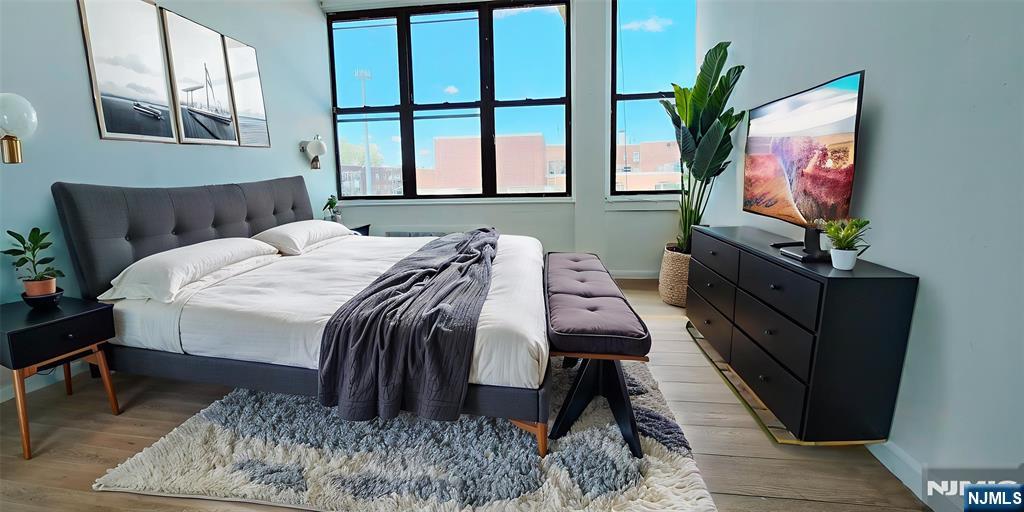 30 Howe Avenue, Unit 305 Passaic, NJ 07055 - Photo 3 of 5 a bedroom with furniture and a flat screen tv