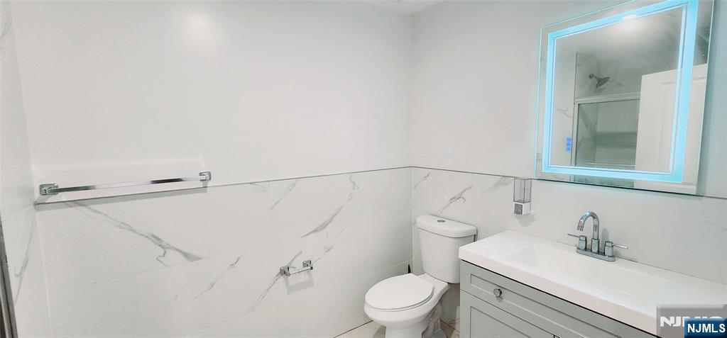 30 Howe Avenue, Unit 305 Passaic, NJ 07055 - Photo 4 of 5 a bathroom with a sink vanity mirror and toilet