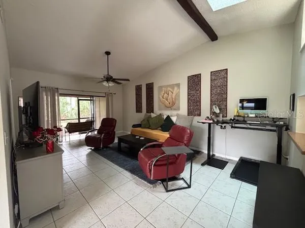 a living room with furniture a flat screen tv and kitchen view