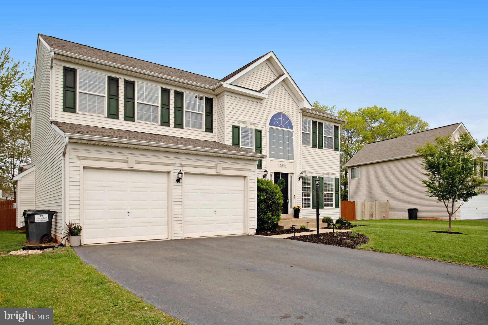 10375 Navarone Place Manassas, VA 20110 - Photo 2 of 51 a view of a white house with a yard and garage
