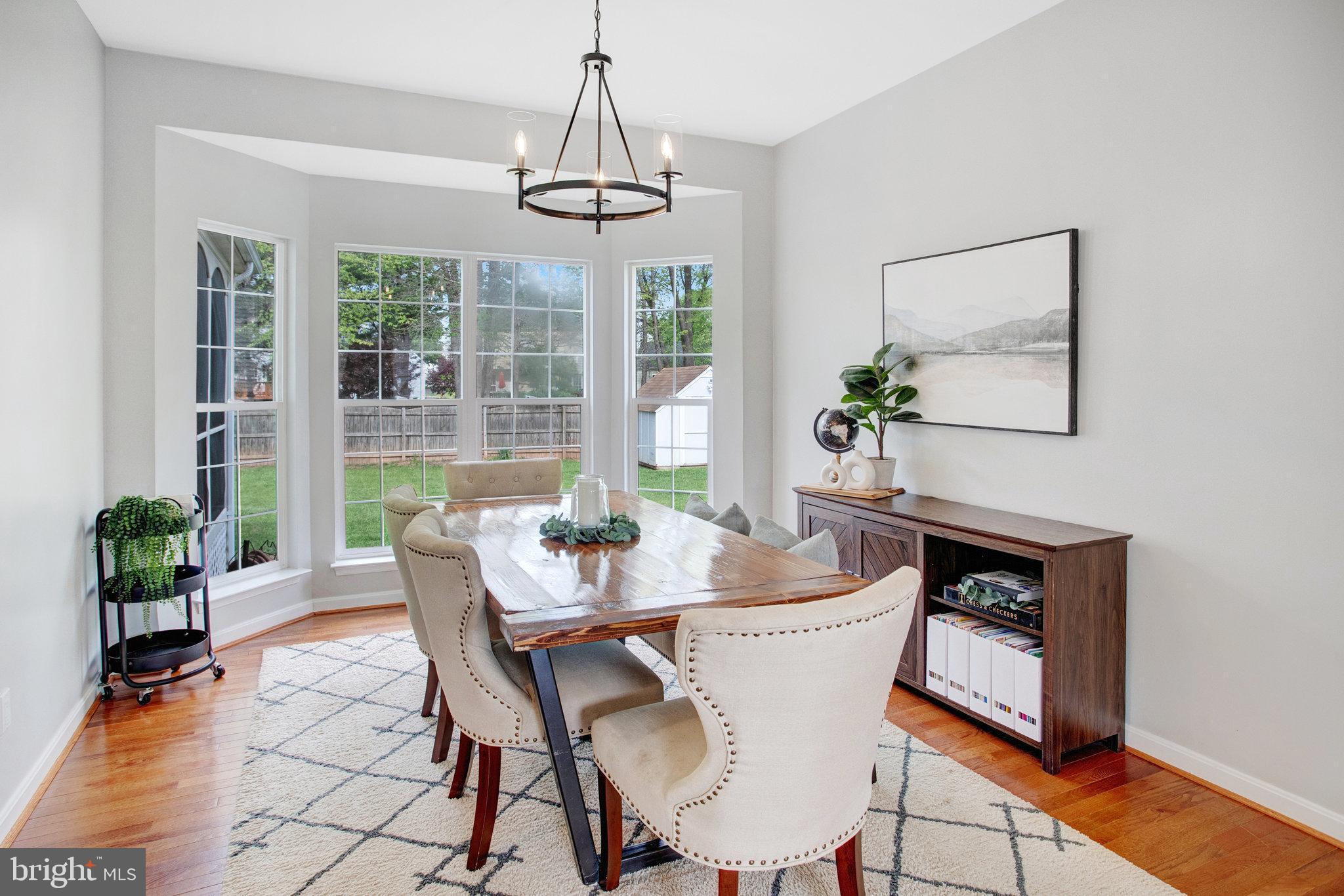 10375 Navarone Place Manassas, VA 20110 - Photo 7 of 51 a dining room with furniture potted plants and wooden floor