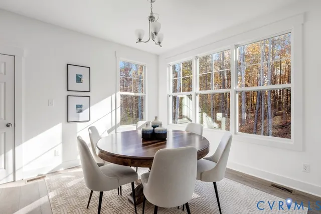 a dining room with furniture a chandelier and wooden floor