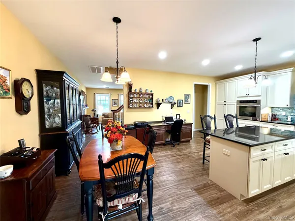 a view of a dining room and livingroom with furniture wooden floor a chandelier