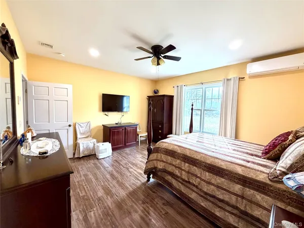 a bedroom with bed tv and window