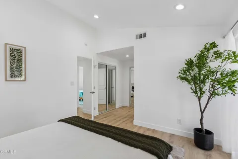 a bedroom with a bed and a potted plant