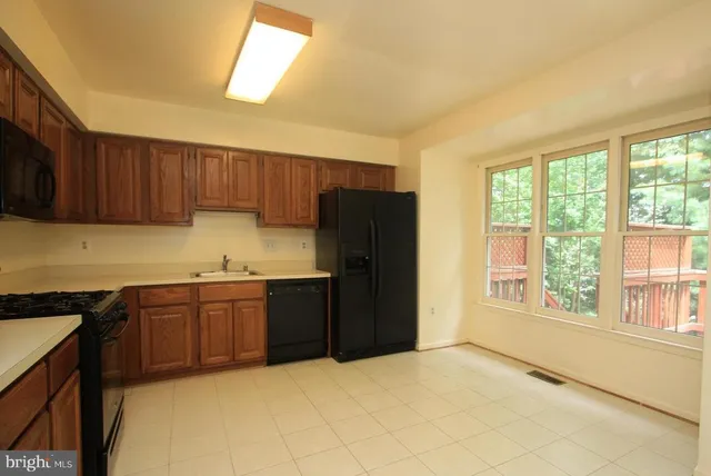 a kitchen with granite countertop a refrigerator cabinets and a stove top oven