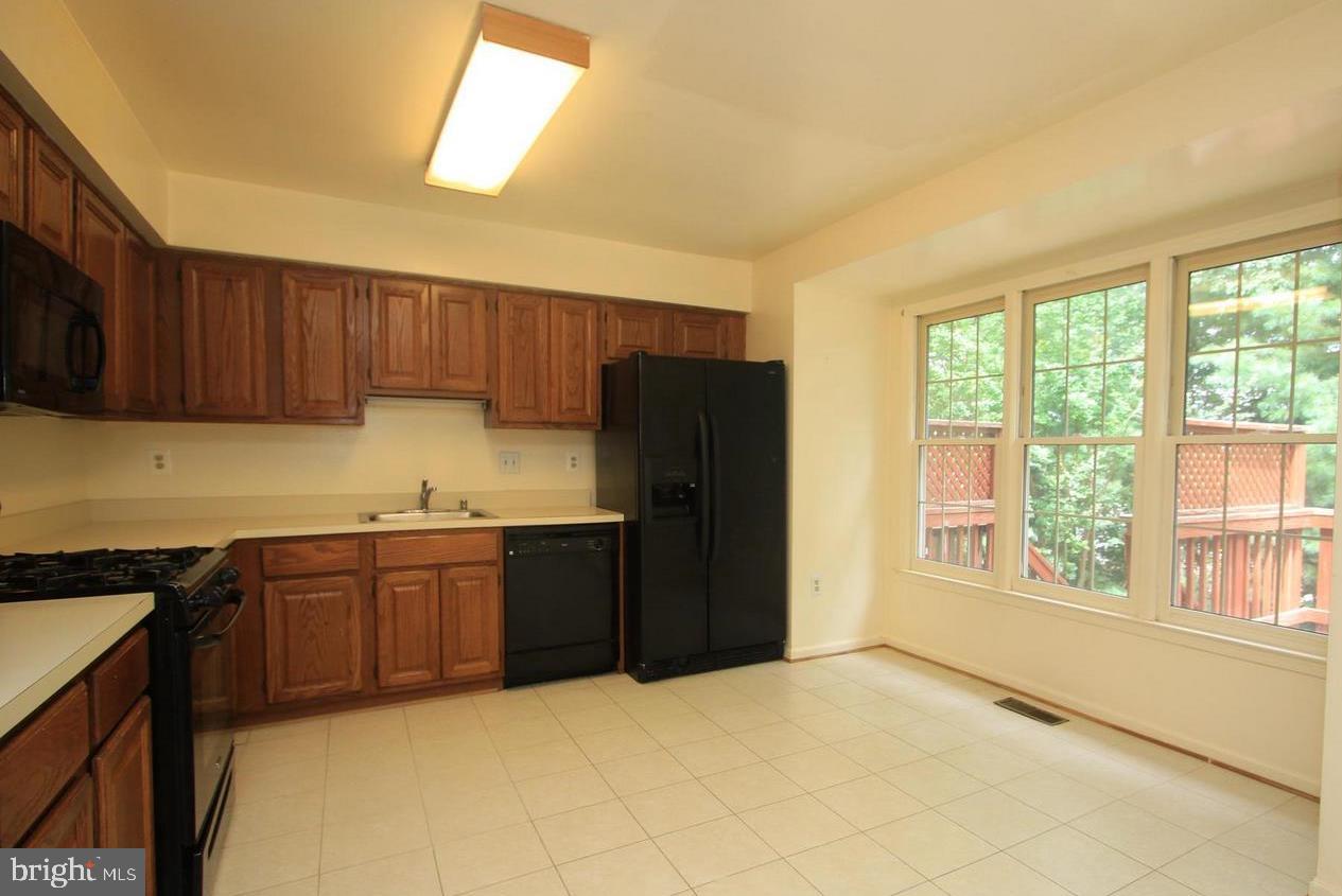 6323 Millwood Circle Springfield, VA 22152 - Photo 2 of 20 a kitchen with granite countertop a refrigerator cabinets and a stove top oven