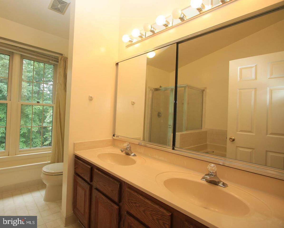 6323 Millwood Circle Springfield, VA 22152 - Photo 9 of 20 a bathroom with a granite countertop sink and a mirror