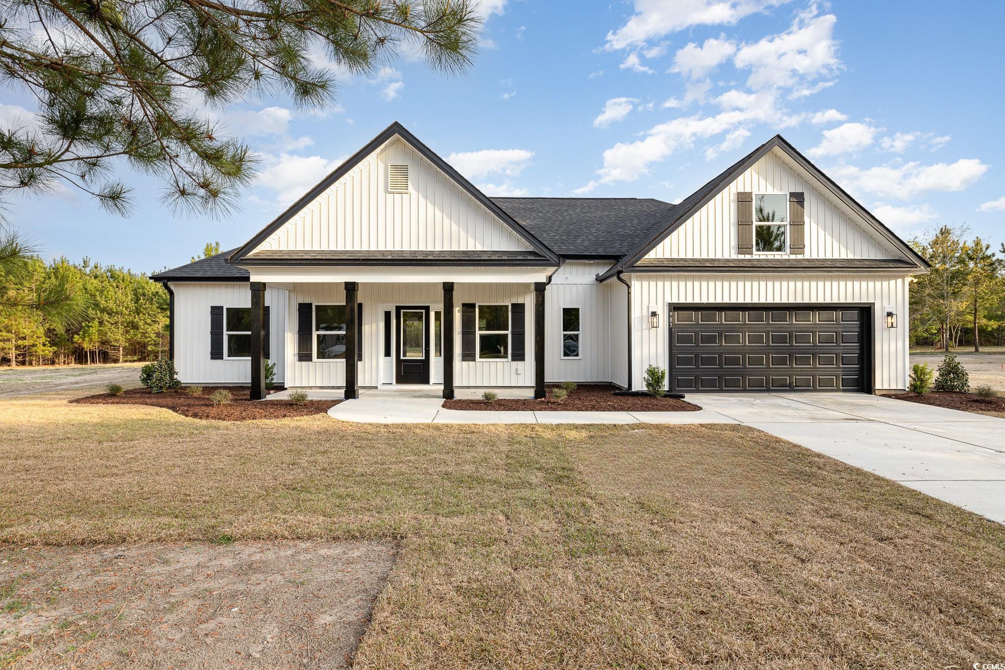 Modern inspired farmhouse with a front yard, a por