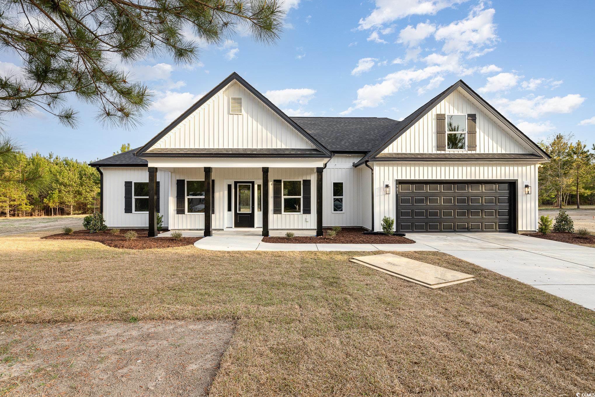 Modern inspired farmhouse with a shingled roof, a