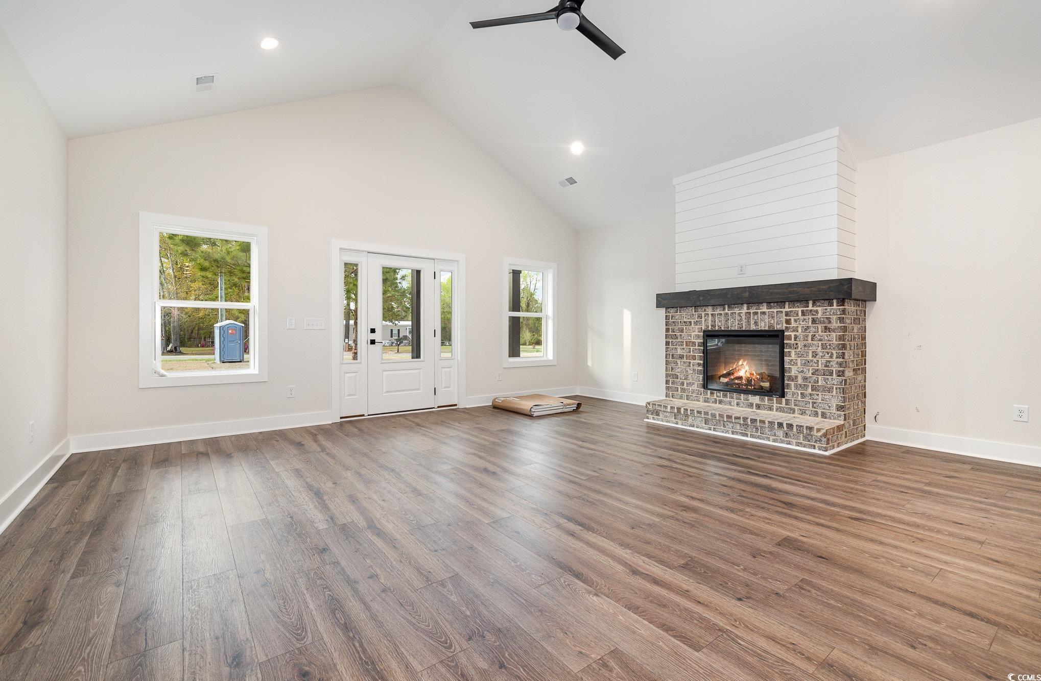 Unfurnished living room featuring high vaulted cei