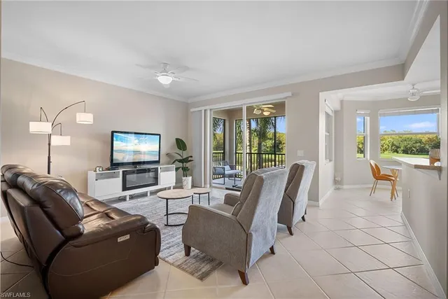 a living room with furniture a potted plant and kitchen view