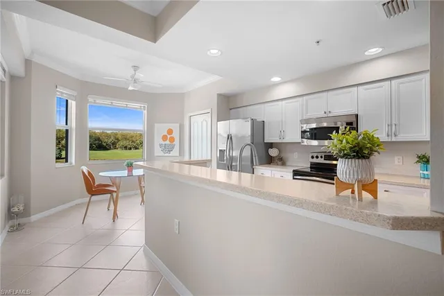 a kitchen with stainless steel appliances kitchen island granite countertop a sink a stove a microwave a counter top space and cabinets