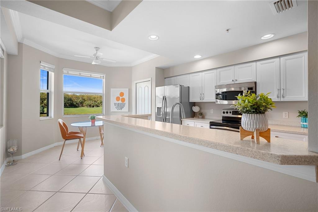 10265 Heritage Bay Boulevard, Unit 622 Naples, FL 34120 - Photo 14 of 50 a living room with furniture a potted plant and kitchen view