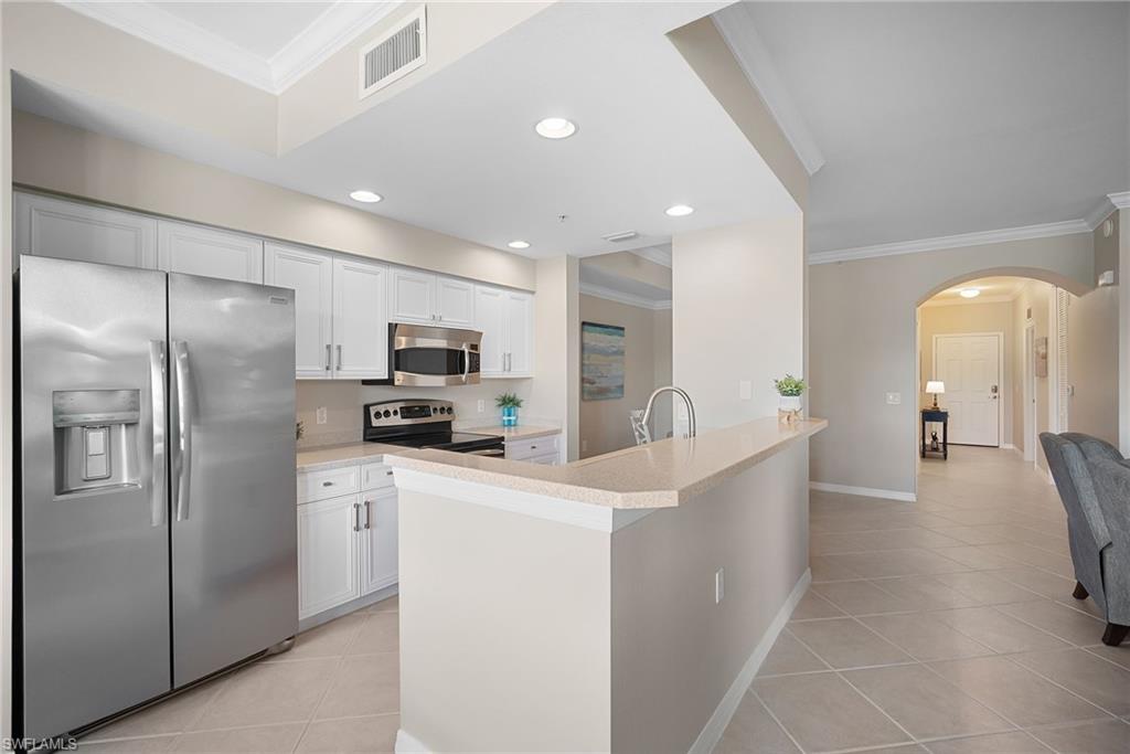 10265 Heritage Bay Boulevard, Unit 622 Naples, FL 34120 - Photo 19 of 50 a kitchen with stainless steel appliances a refrigerator sink and cabinets
