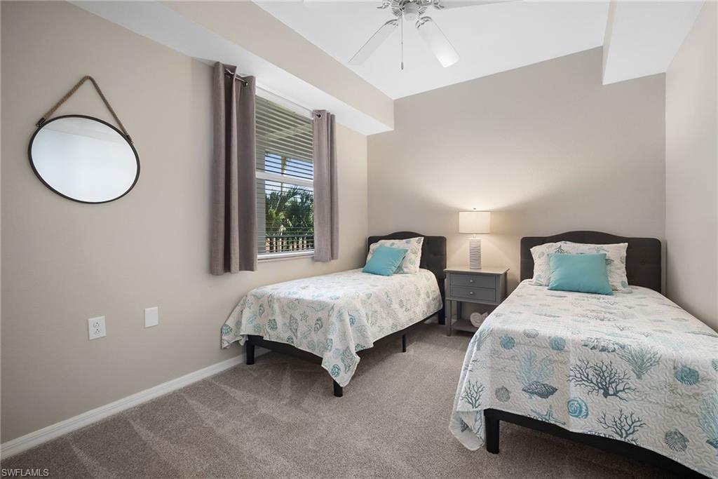 10265 Heritage Bay Boulevard, Unit 622 Naples, FL 34120 - Photo 28 of 50 a bedroom with two beds and a chandelier