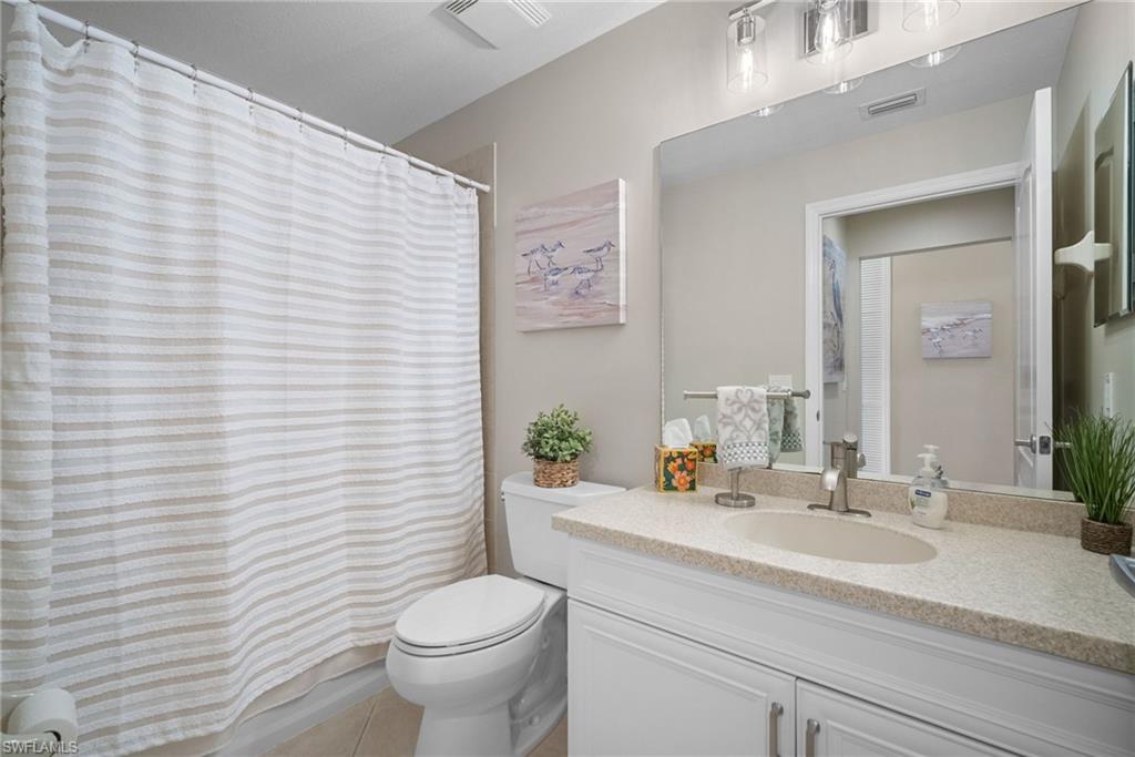 10265 Heritage Bay Boulevard, Unit 622 Naples, FL 34120 - Photo 30 of 50 a bathroom with a sink a toilet and mirror