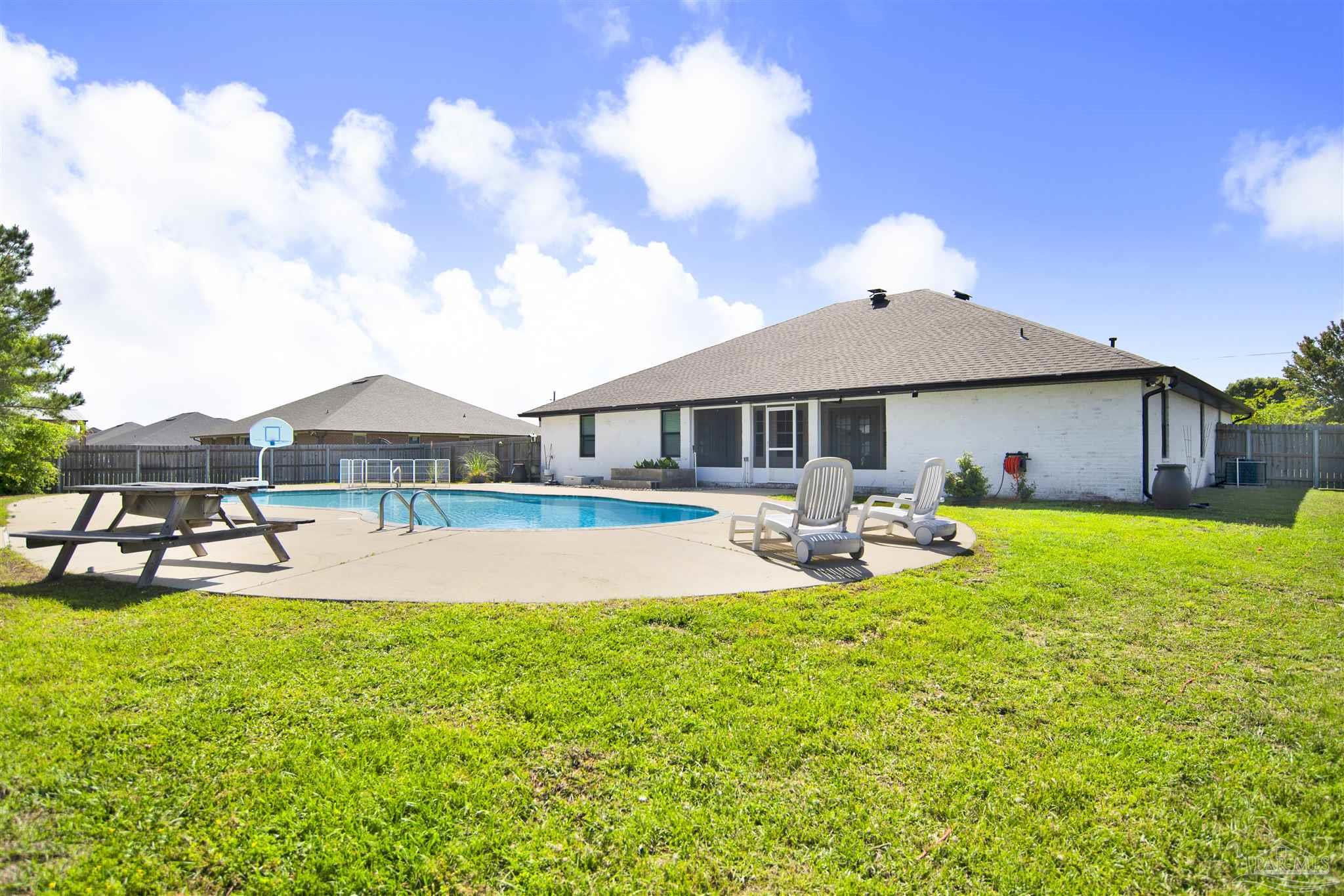 2810 Wallace Lake Road Pace, FL 32571 - Photo 59 of 65 a view of pool with table and chairs under an umbrella