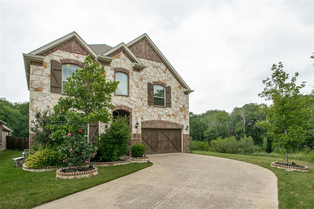 a front view of a house with a yard and trees