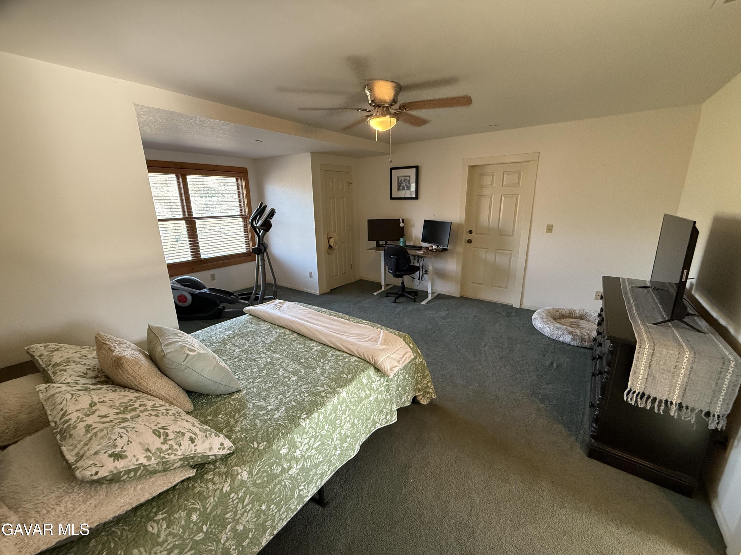 28147 Lake Wohlford Road Valley Center, CA 92082 - Photo 15 of 25 a spacious bedroom with a bed a couch and a window