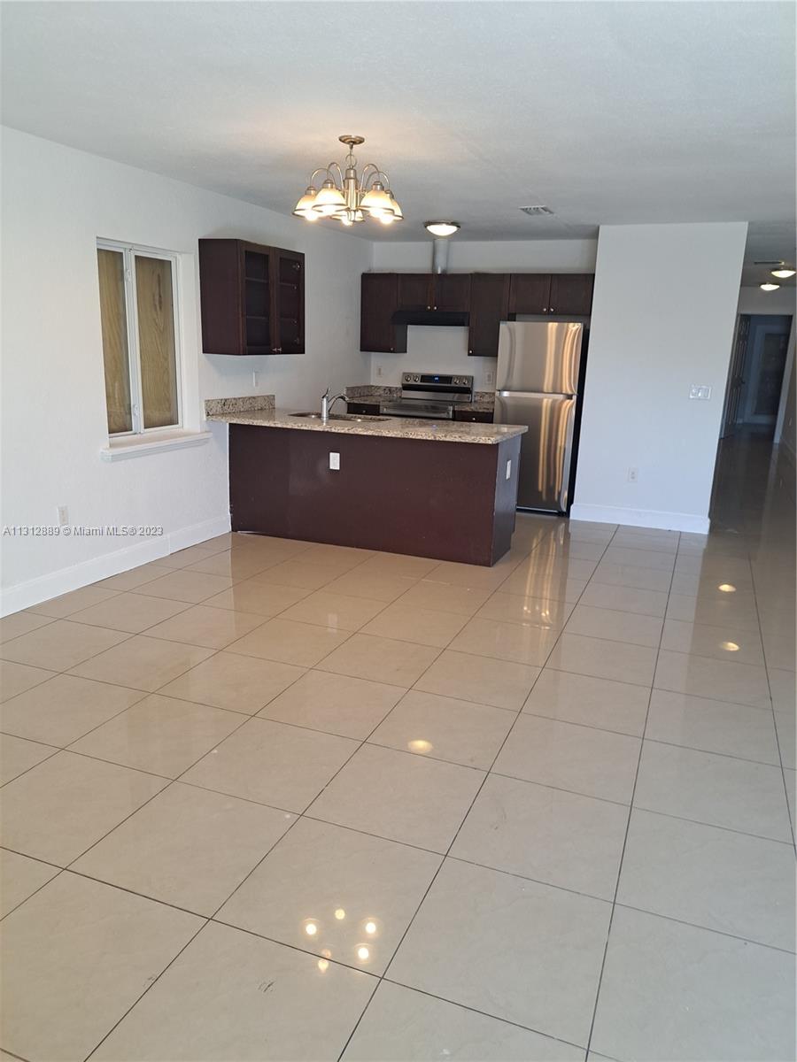 659 Northwest 47th Street, Unit 659 Miami, FL 33127 - Photo 3 of 9 a living room with furniture a flat screen tv and a fireplace