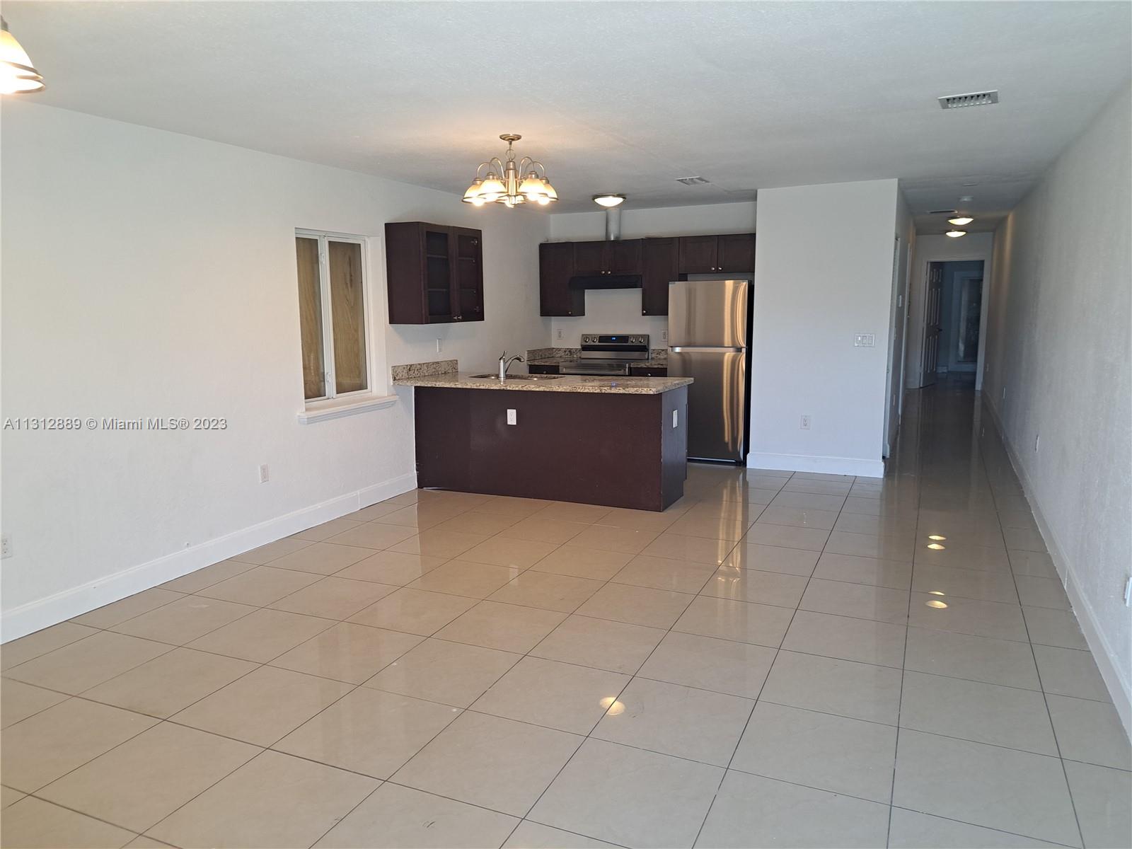 659 Northwest 47th Street, Unit 659 Miami, FL 33127 - Photo 4 of 9 a large kitchen with a sink and cabinets