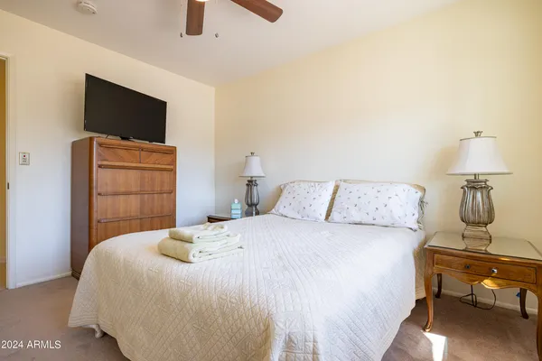 a bedroom with a bed tv and chair