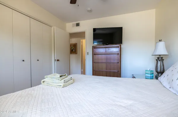 a bedroom with a bed and a flat screen tv