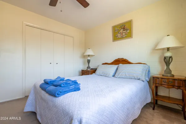 a bedroom with a bed and a lamp on the dresser