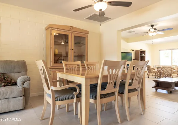 a view of a dining room with furniture and a chandelier fan