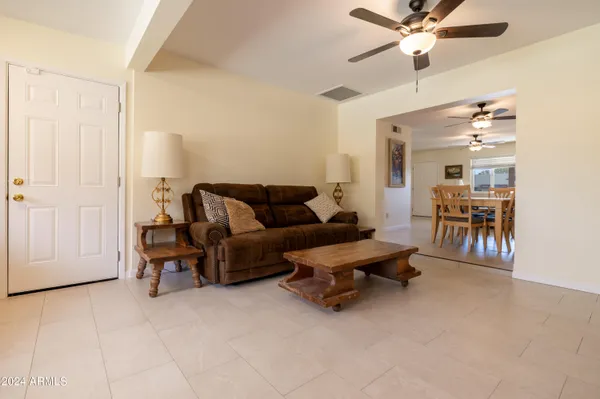 a living room with furniture and a ceiling fan
