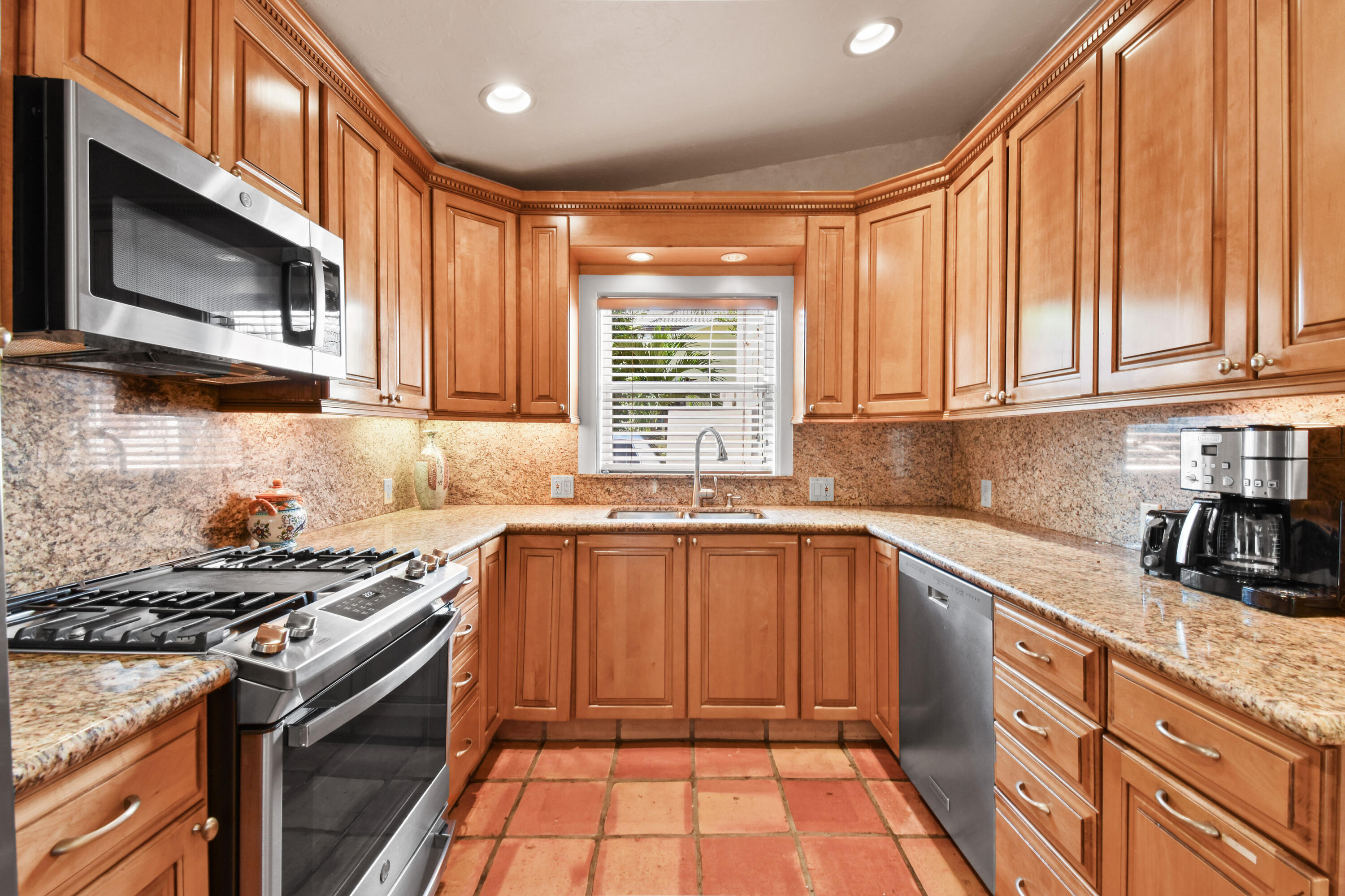 194 Almeria Road West Palm Beach, FL 33405 - Photo 26 of 67 a kitchen with stainless steel appliances granite countertop a stove a sink and a microwave
