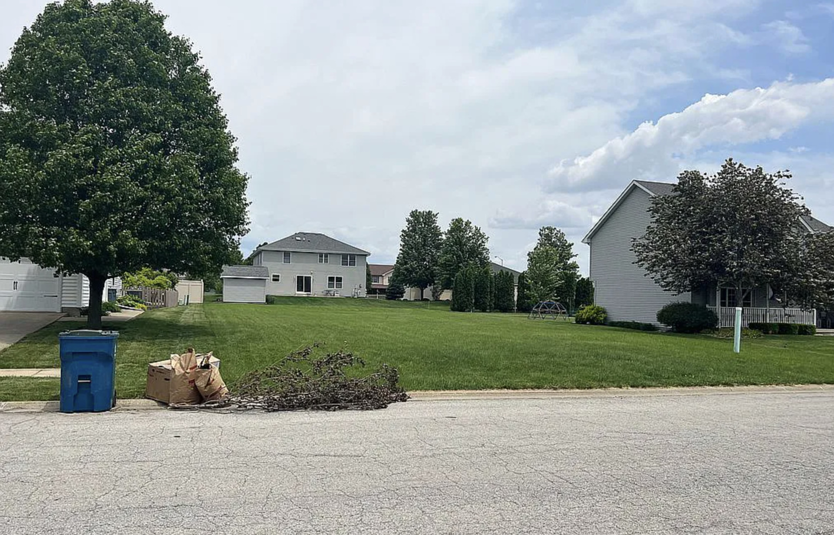 a view of a house with a yard and large trees