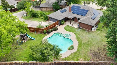 an aerial view of a house with a garden and trees