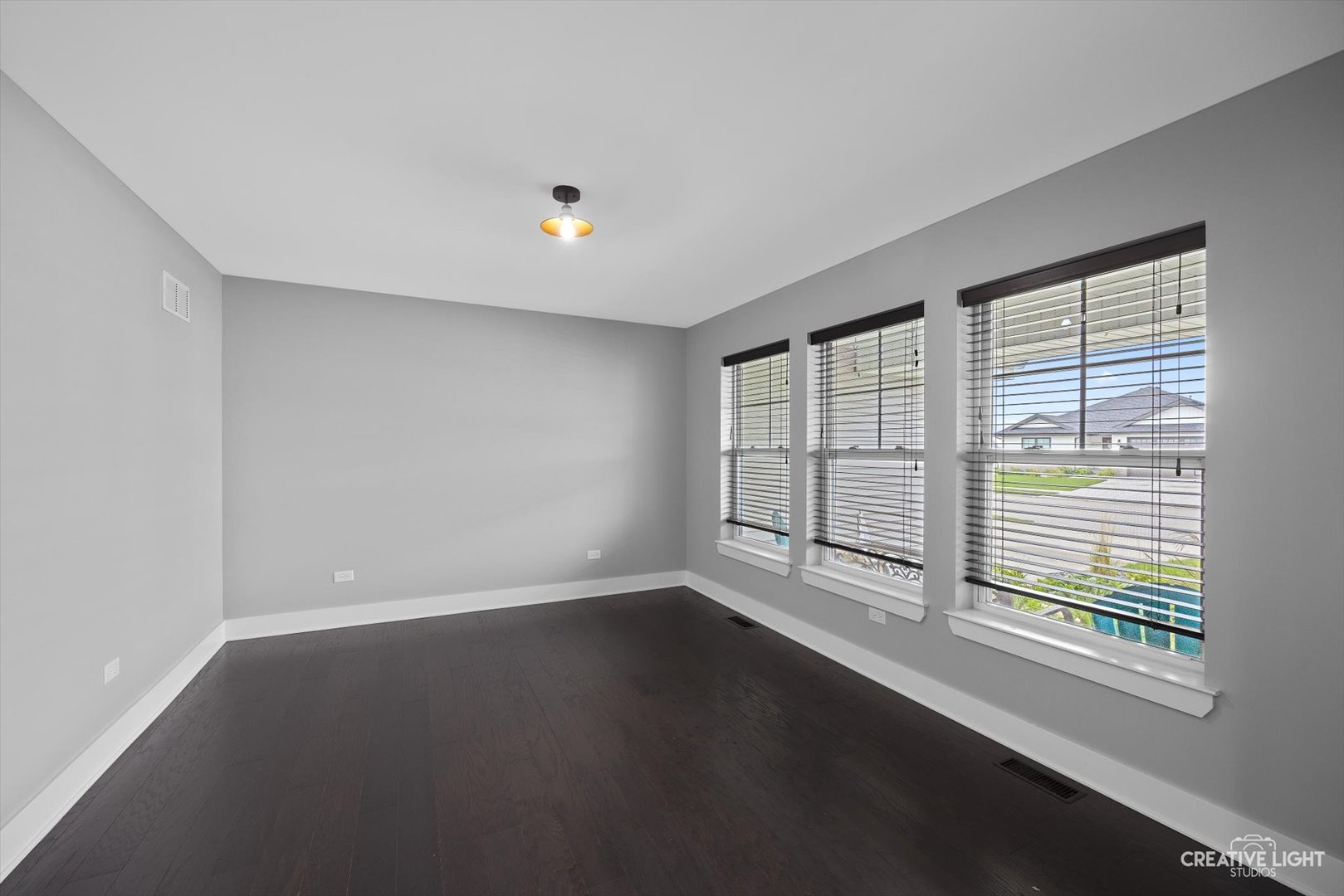 618 Peacock Place Manteno, IL 60950 - Photo 7 of 31 an empty room with wooden floor and windows