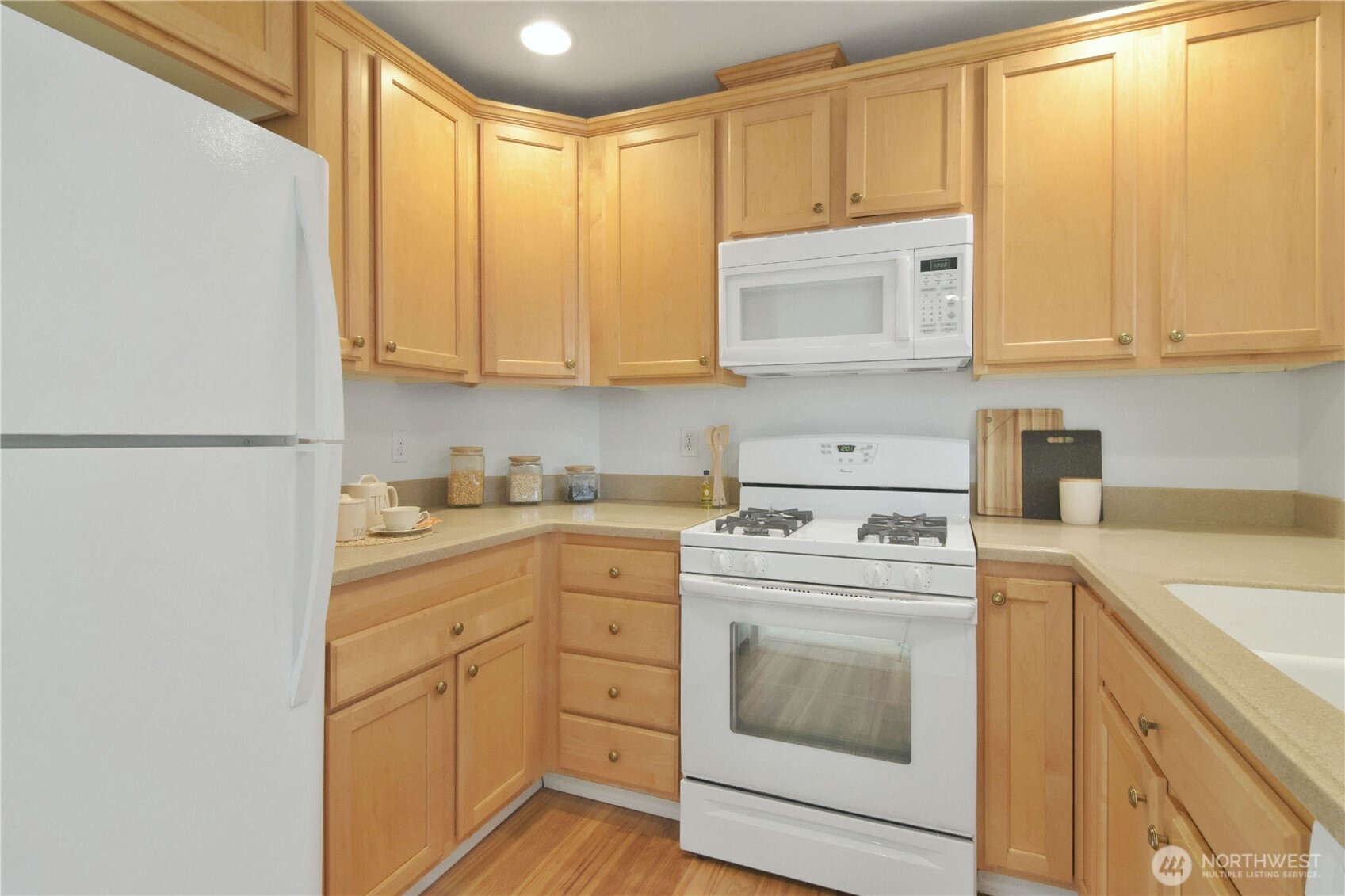 8500 Main Street, Unit F313 Edmonds, WA 98026 - Photo 12 of 24 a kitchen with white cabinets and white appliances