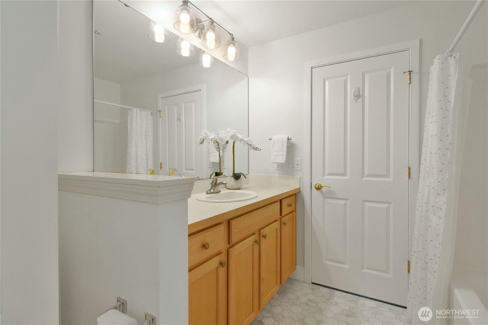 8500 Main Street, Unit F313 Edmonds, WA 98026 - Photo 19 of 24 a bathroom with a sink a mirror and a vanity