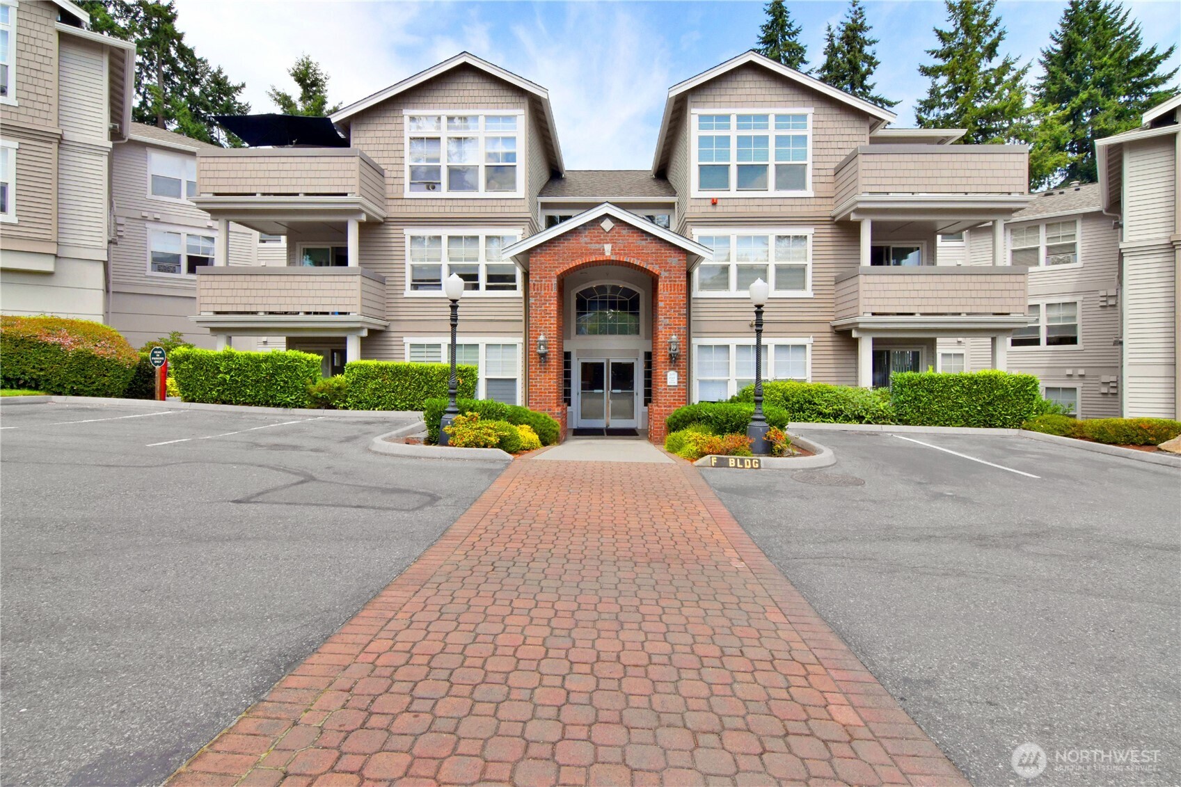 8500 Main Street, Unit F313 Edmonds, WA 98026 - Photo 2 of 24 a front view of a house with a yard and a garage